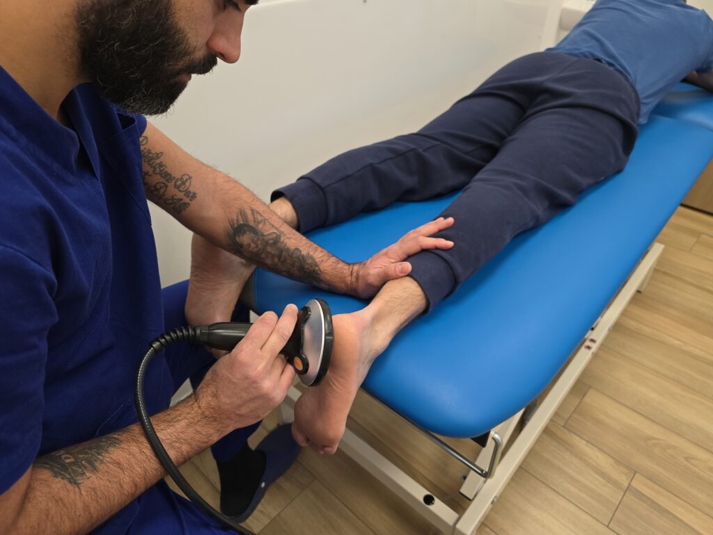 Terapista esegue trattamento con onde d'urto sul tallone di un paziente per alleviare il dolore causato dalla spina calcaneare al Centro Medico La Fenice di Bracciano.